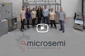 L'équipe Microsemi posant devant des équipements de nettoyage par ultrasons ; logo Microsemi avec slogan "NETTOYAGE PAR ULTRASONS DEPUIS 1985".